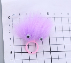 Detail view of purple plush monster ring showing the soft texture and adjustable pink band