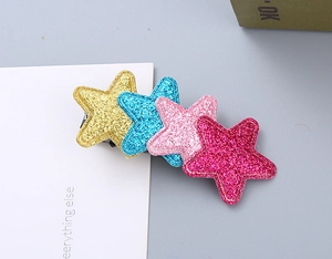 Detail view of colorful glitter star hair clips with four pentagram shapes for girls