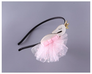 Detail of swan headband with pink tulle ballet skirt and golden sequin crown for girls