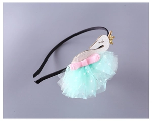 Detail of children's swan headband with golden crown and mint green tulle tutu skirt