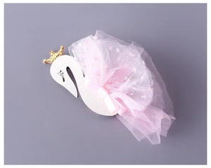 Detailed close-up of a white swan crown headband with pink mesh and ribbon bow details