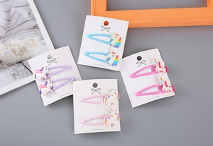 Detalle de bonitas pinzas para el pelo de unicornio con purpurina en tarjeta blanca