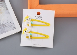 Detalle de pinzas para el pelo de unicornio amarillas en tarjeta de exhibición