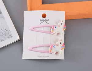 Detalle de pinzas para el cabello de unicornio rosa con purpurina para niñas en cartón blanco
