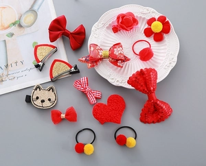 Flat lay detail of 13pcs red festive hair bow clips and accessories for kids