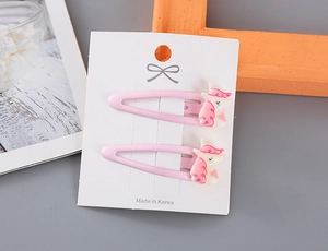 Detalle de pinzas de pelo de unicornio rosa con purpurina para niñas en tarjeta