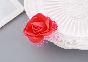 Close-up of handmade red foam rose hair clip with pink sequin mesh details