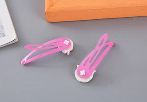 Detalle de pinzas para el cabello BB rosas para niñas con adornos blancos de estrellas
