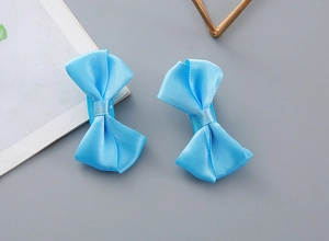 Close-up of sky blue satin bow hair clips with premium silk texture and smooth finish