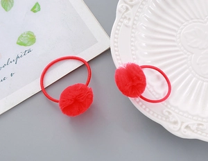Detail view of two red mesh pom-pom hair ties with soft texture for festive occasions