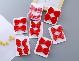 Detail of red festive girl's hair clip set with 14 pieces including velvet and pearl bows