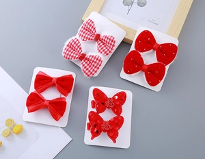 Detail of red festive girl's hair clip set with velvet bows and Fu character embellishments