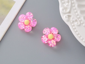 Detailed view of pink resin flower ear clips with sparkling glitter for kids and girls