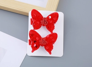 Detail of red festive plush bow hair clips with glitter Fu character for girls