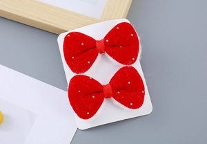 Close-up of red festive plush bow hair clips with sparkling glitter for girls
