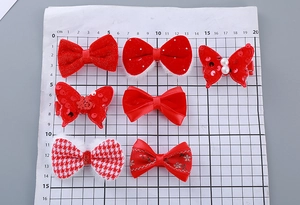 Detail of red festive children's hair clips with velvet bows and sequined butterfly patterns