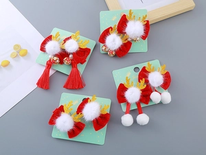 Détail de nœuds festifs en velours rouge avec bois de renne dorés et pompons sur support