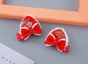 Détail de pinces à cheveux oreilles de chat en peluche rouge avec broderie dorée