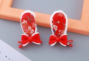 Détail de pinces à cheveux oreilles de lapin rouges en peluche avec nœuds mignons