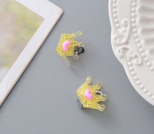 Detailed view of kids resin crown hair clip with golden glitter and pink heart