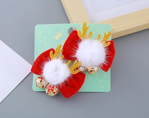 Détail de pinces à cheveux bois de renne avec nœuds rouges, pompons et clochettes