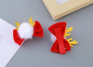 Détail de pinces à cheveux de Noël avec nœuds rouges brillants, pompons et bois dorés