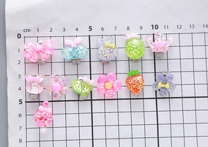 Close-up of colorful resin hair clips with glitter in butterfly and crown shapes