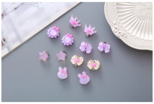 Détail de clips d'oreilles en résine violette avec motifs de dessins animés pour enfants