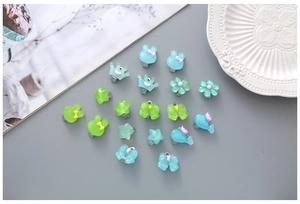 Détail de clips d'oreilles mignons en résine translucide aux formes assorties