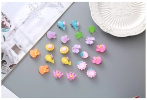 Vue détaillée des boucles d'oreilles clips en résine translucide aux formes de dessins
