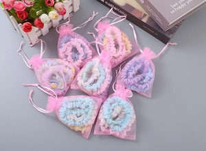 Detailansicht bunter Organza-Haargummis in rosa Geschenkbeuteln für Mädchen-Haarschmuck