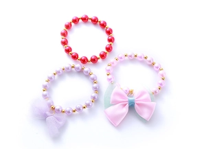 Detailed view of children's pearl bracelets with bow charms and gold spacer beads