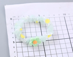 Detailansicht eines floralen Organza-Haargummis mit ca. 7 cm Durchmesser auf Raster