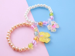 Detailed macro view of colorful beaded children's bracelets with resin bow pendants