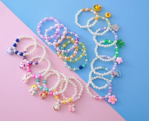 Détail de bracelets de perles colorés avec pendentifs de dessins animés pour fillettes