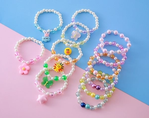 Détail de bracelets de perles pour enfants avec breloques de dessin animé colorées