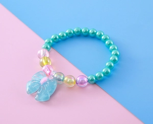 Close-up of children's colorful beaded bracelet with a large blue resin bow pendant