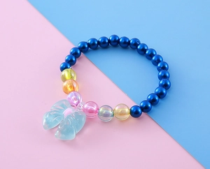Detailed top view of kids beaded bracelet with blue pearls and a butterfly pendant