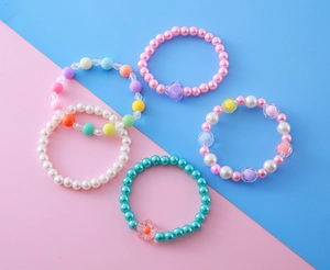 Détail de cinq bracelets assortis pour enfants avec perles colorées et breloques mignonnes