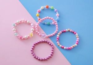 Vue détaillée de 5 bracelets de perles colorées pour filles avec perles pastel et motifs floraux