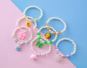 Détail de bracelets de perles colorés pour enfants avec breloques et fausses perles