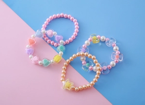 Détails de quatre bracelets de perles colorés pour filles avec cœurs et étoiles