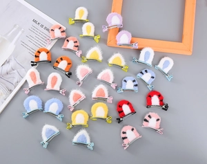 Flat lay of colorful plush cat ear hair clips for girls in various vibrant patterns