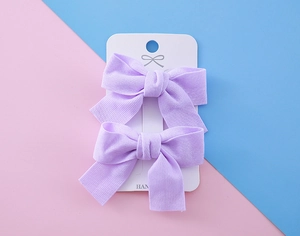 Détail de barrettes à nœuds en tissu violet clair pour filles, lot de deux sur carte