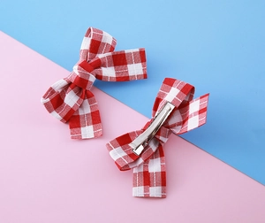 Détail de nœuds papillon à carreaux rouges et blancs avec pinces croco en métal et coton