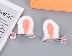 Detail of plush pink and white rabbit ear hair clips with ribbon-wrapped duckbill clips