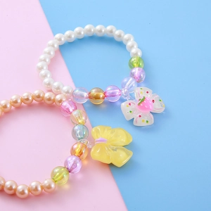 Colorful beaded kids bracelets with imitation pearls, resin bows and strawberry charms