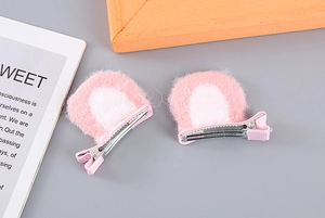Detail of pink and white plush cat ear hair clips with fabric wrapped metal duckbill clips