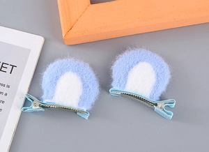 Detail of plush cat ear hair clips with light blue faux fur and metal duckbill base