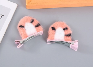 Detail showing plush orange cat ear hair clips with tiger stripes and pink fabric wrap